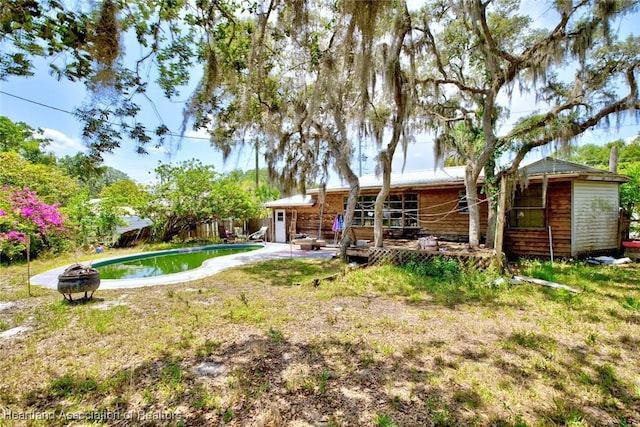 1320 Lakeview Dr, Sebring, FL 33870 - rear view of property with an outdoor pool, a wooden deck, and fence