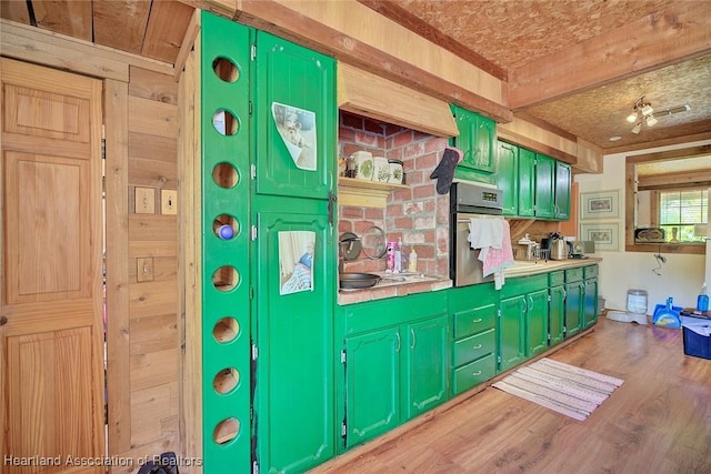 1320 Lakeview Dr, Sebring, FL 33870 - kitchen featuring stainless steel oven, green cabinetry, wood finished floors, wood walls, and light countertops