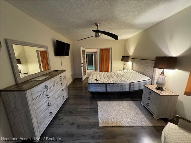 unfurnished bedroom with a textured ceiling, ceiling fan, dark wood-type flooring, and vaulted ceiling