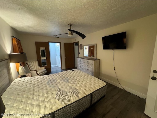 bedroom with a textured ceiling, ceiling fan, and dark wood-type flooring