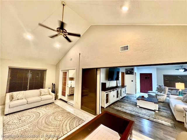 living room featuring ceiling fan, french doors, high vaulted ceiling, and hardwood / wood-style flooring