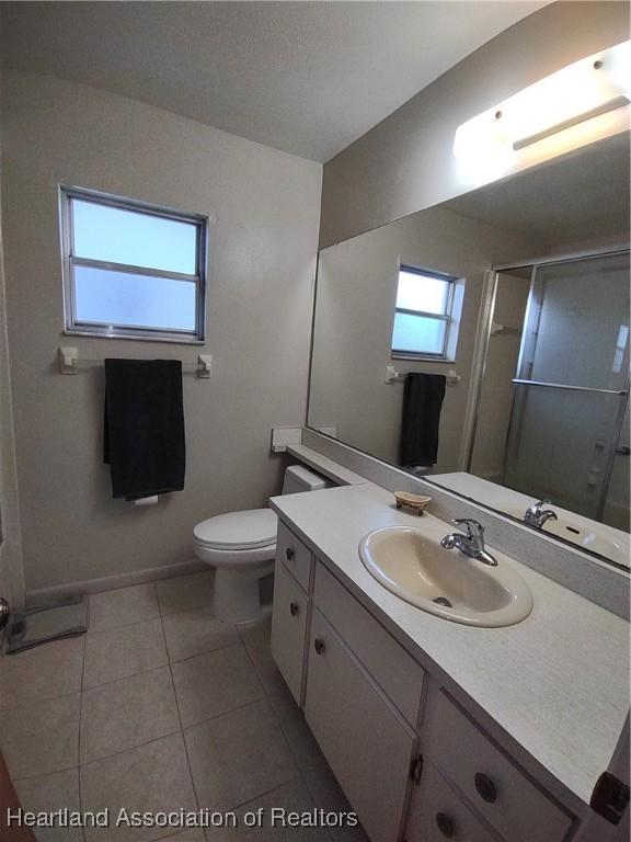 160 Parkview Cir, Lake Placid, FL 33852 - full bath with baseboards, toilet, tile patterned floors, vanity, and a stall shower
