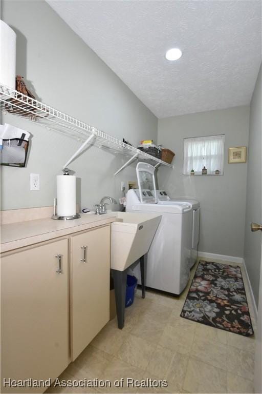 laundry room featuring a textured ceiling, recessed lighting, washing machine and clothes dryer, baseboards, and cabinet space