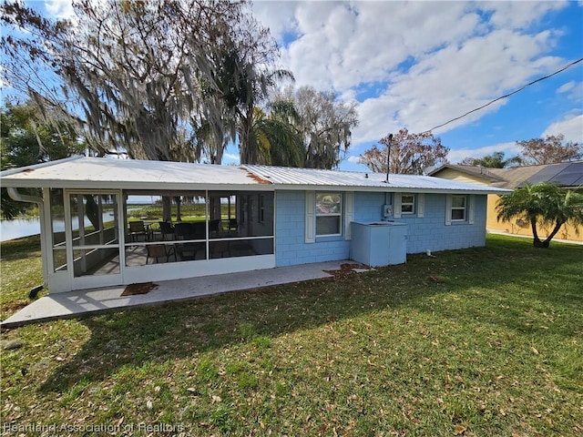 back of house featuring a sunroom and a yard