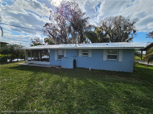 back of house with a yard and a patio