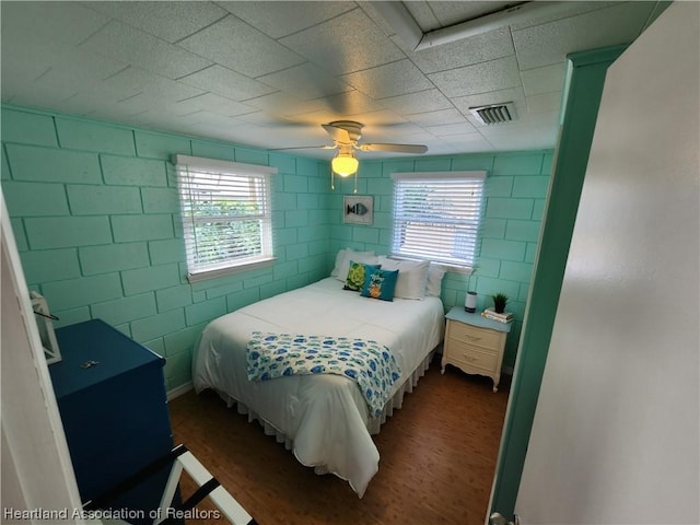 bedroom with multiple windows, ceiling fan, and dark hardwood / wood-style floors