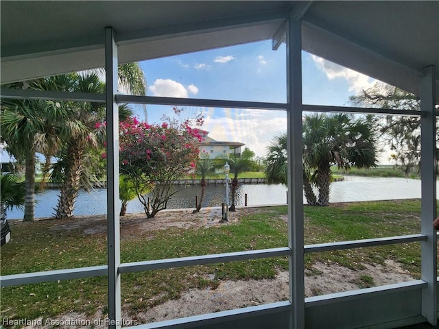 exterior space featuring a water view, lofted ceiling, and a wealth of natural light