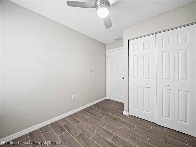 unfurnished bedroom featuring ceiling fan and a closet