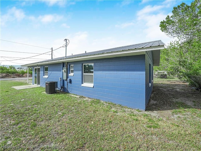 rear view of house with a lawn and central air condition unit