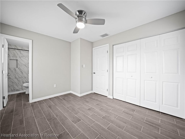 unfurnished bedroom featuring dark wood-type flooring, ceiling fan, ensuite bathroom, and a closet