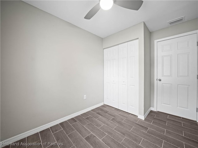 unfurnished bedroom with ceiling fan and a closet