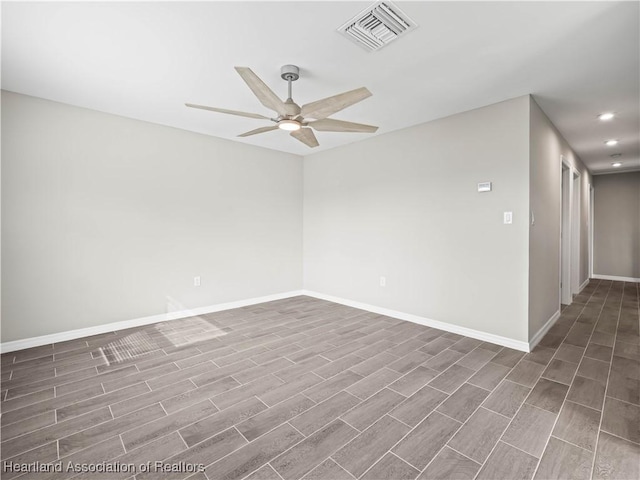 spare room featuring dark wood-type flooring and ceiling fan