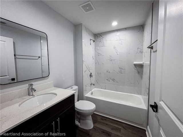 full bathroom featuring vanity, toilet, wood-type flooring, and tiled shower / bath