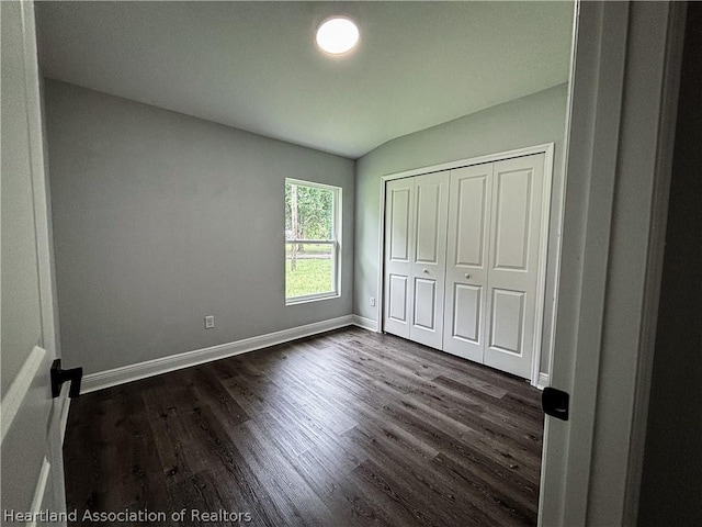 unfurnished bedroom with dark wood-type flooring and a closet