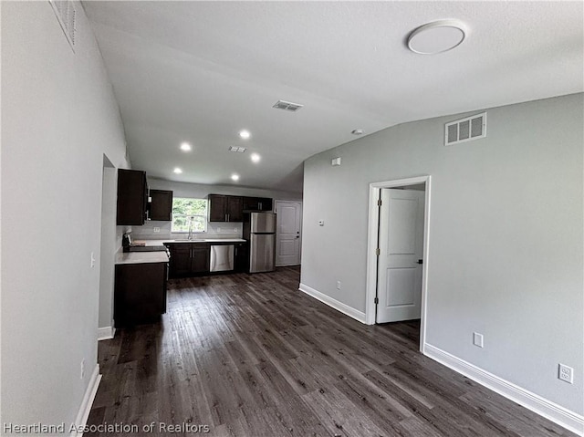 kitchen with sink, dark wood-type flooring, lofted ceiling, and appliances with stainless steel finishes