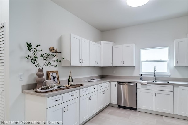 kitchen featuring stainless steel dishwasher, white cabinets, light tile patterned floors, and sink