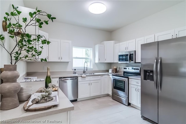 kitchen with appliances with stainless steel finishes, white cabinetry, and sink