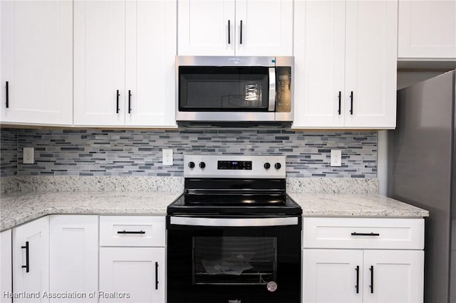 kitchen with backsplash, appliances with stainless steel finishes, light stone counters, and white cabinets