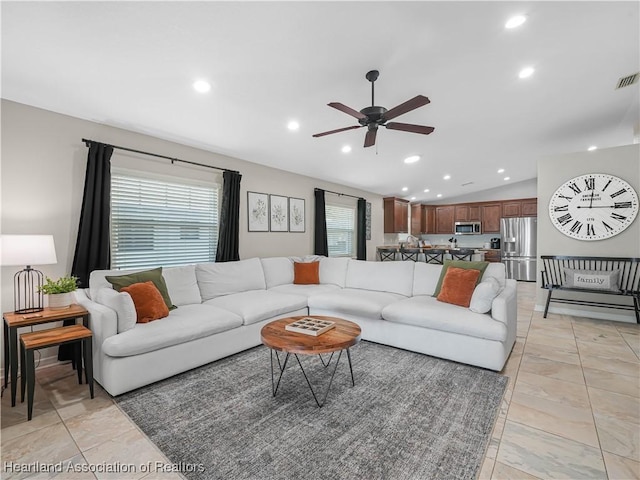 living room with vaulted ceiling, light tile patterned floors, and ceiling fan