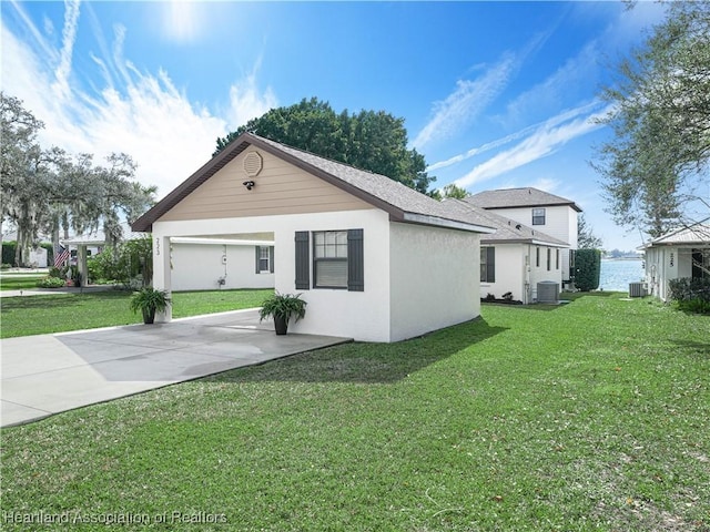 view of property exterior with concrete driveway, central AC, a lawn, and stucco siding