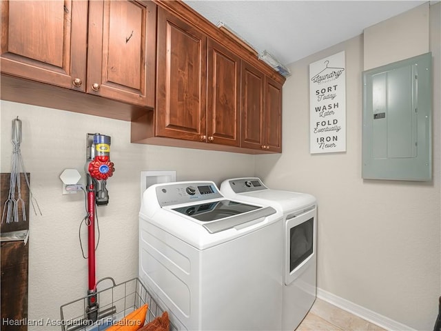 laundry area featuring washing machine and dryer, electric panel, cabinet space, and baseboards