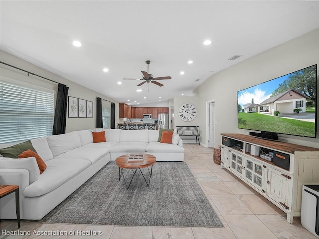 living room with vaulted ceiling, light tile patterned floors, and ceiling fan