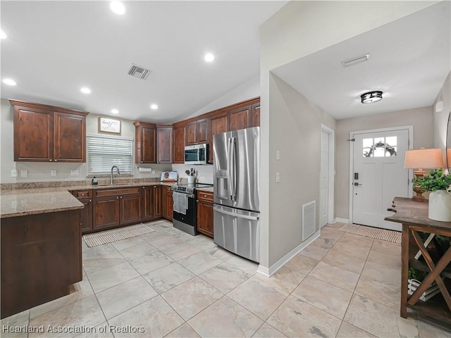 kitchen with light stone counters, appliances with stainless steel finishes, a sink, and visible vents