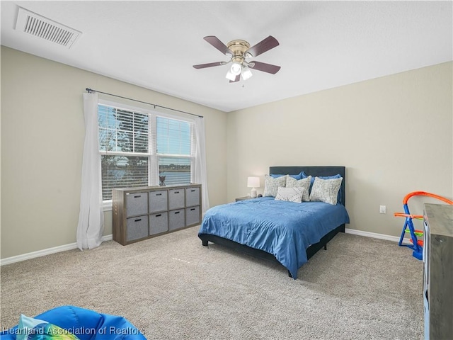 carpeted bedroom featuring baseboards, visible vents, and ceiling fan