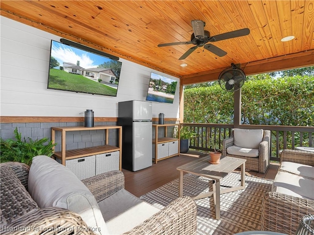 wooden deck featuring outdoor lounge area and ceiling fan