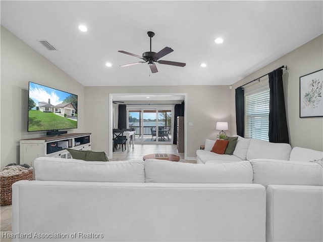 living room featuring ceiling fan, vaulted ceiling, and a wealth of natural light