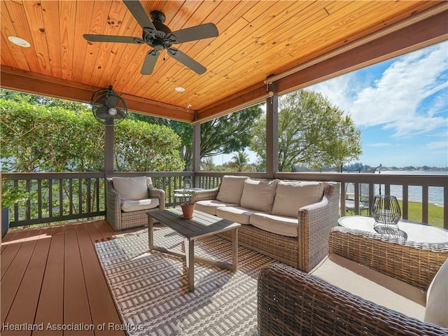 wooden deck featuring a water view, ceiling fan, and an outdoor living space