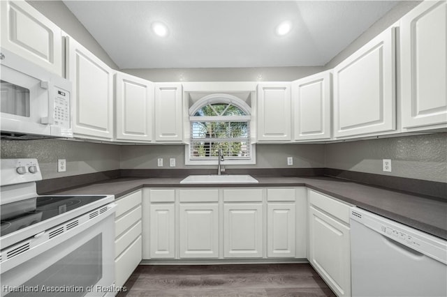 kitchen with white appliances, white cabinetry, dark wood-type flooring, and sink