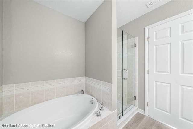 bathroom featuring plus walk in shower and wood-type flooring