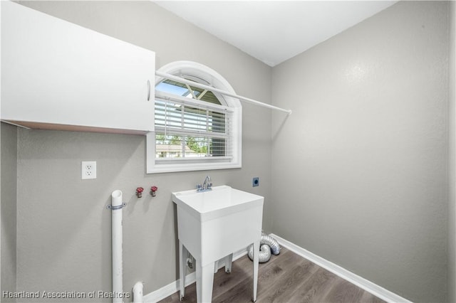 laundry area with hookup for an electric dryer and wood-type flooring