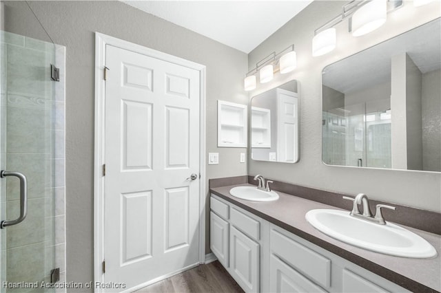 bathroom with vanity, an enclosed shower, and hardwood / wood-style flooring