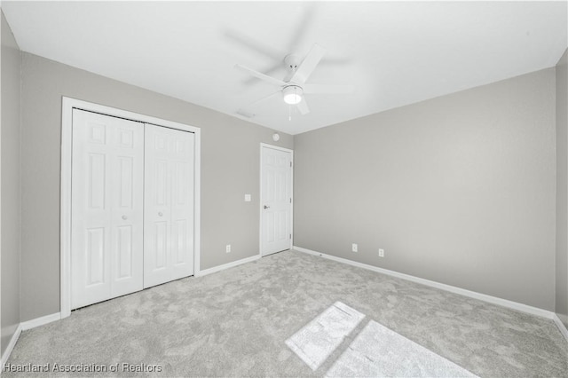 unfurnished bedroom featuring ceiling fan, light colored carpet, and a closet