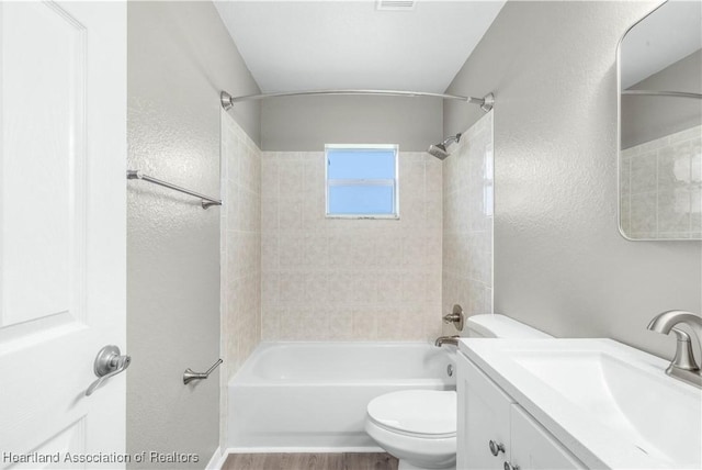 full bathroom with vanity, toilet, and tiled shower / bath combo