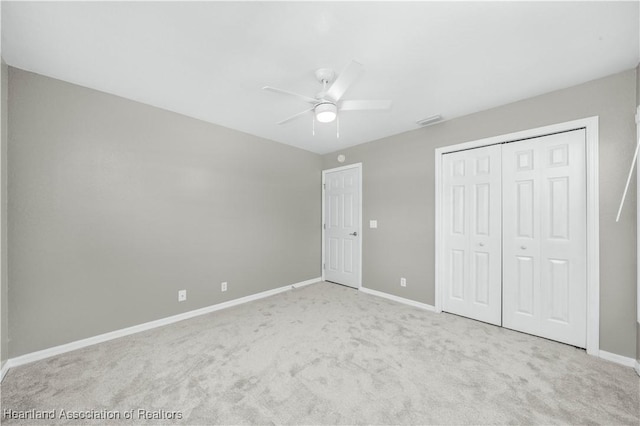 unfurnished bedroom featuring a closet, ceiling fan, and light colored carpet