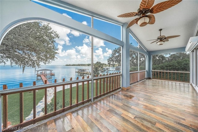 unfurnished sunroom featuring ceiling fan, a water view, and vaulted ceiling