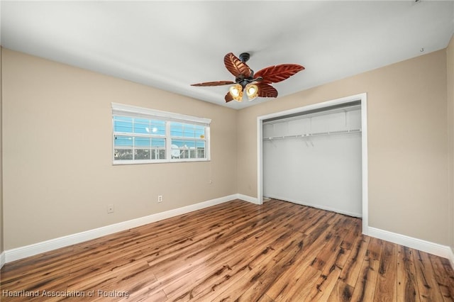 unfurnished bedroom with wood-type flooring, a closet, and ceiling fan