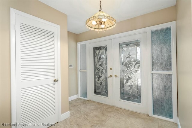 doorway to outside featuring french doors and an inviting chandelier