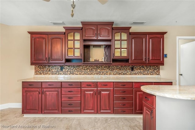 kitchen featuring light stone countertops, light tile patterned floors, and tasteful backsplash