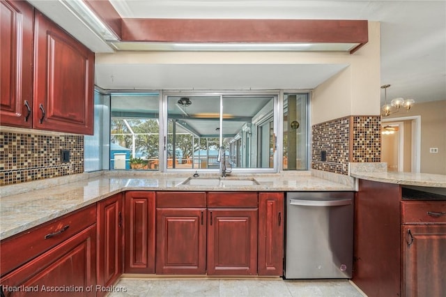 kitchen with light stone countertops, stainless steel dishwasher, sink, pendant lighting, and a chandelier