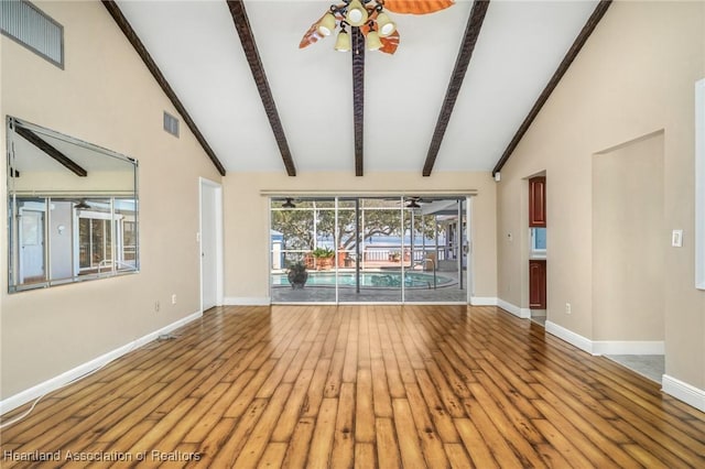 unfurnished living room with ceiling fan, hardwood / wood-style floors, and vaulted ceiling