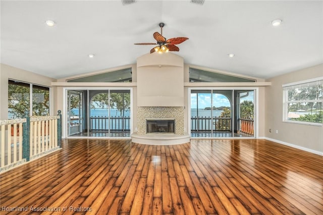 unfurnished living room with ceiling fan, a fireplace, lofted ceiling, and hardwood / wood-style flooring