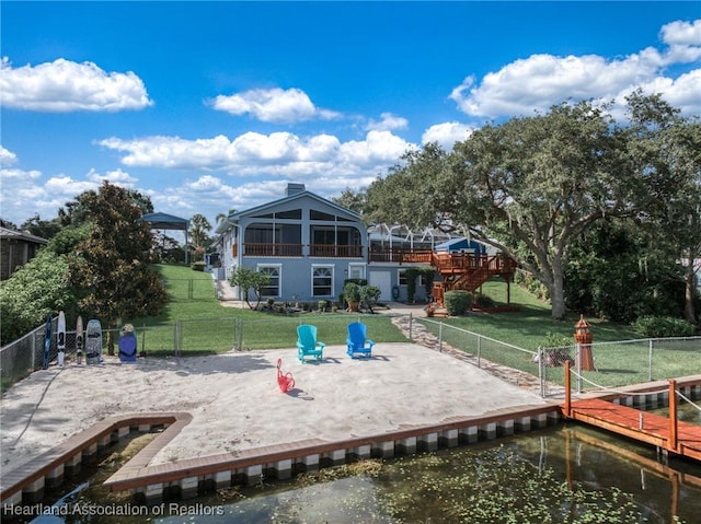 rear view of house featuring a water view and a yard