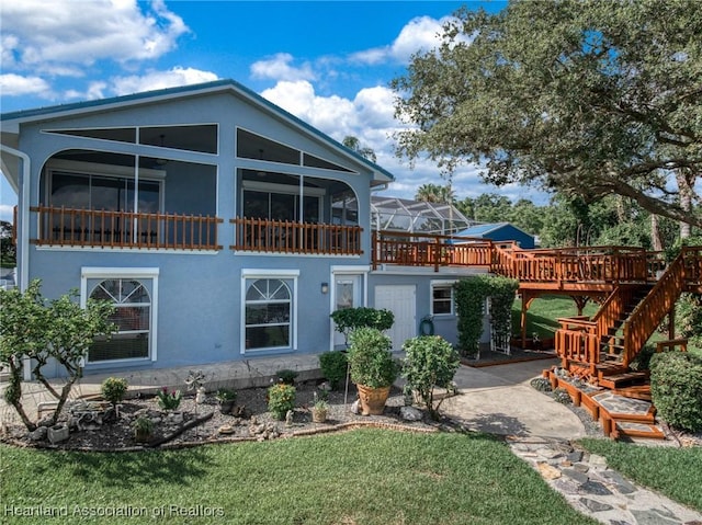 back of property featuring a sunroom and a yard