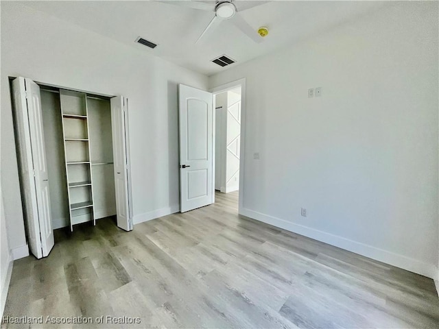 unfurnished bedroom featuring ceiling fan, light hardwood / wood-style floors, and a closet