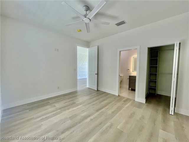 unfurnished bedroom with ceiling fan, light hardwood / wood-style floors, connected bathroom, and a closet