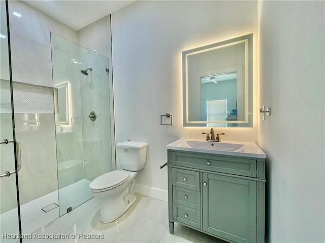 bathroom featuring toilet, tile patterned flooring, walk in shower, and vanity